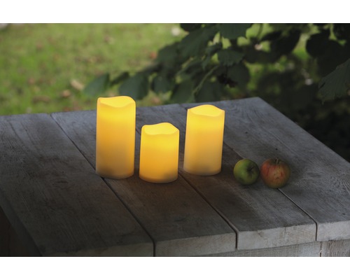 Drei LED Kerzen auf einem Holztisch im Außenbereich