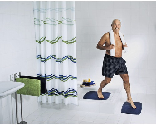 Salle de bain lumineuse avec rideau de douche, tapis de bain et une personne avec une serviette