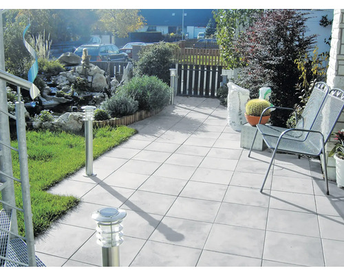 Terrasse avec jardin, équipée de mobilier de jardin, de dalles de sol et de luminaires extérieurs.