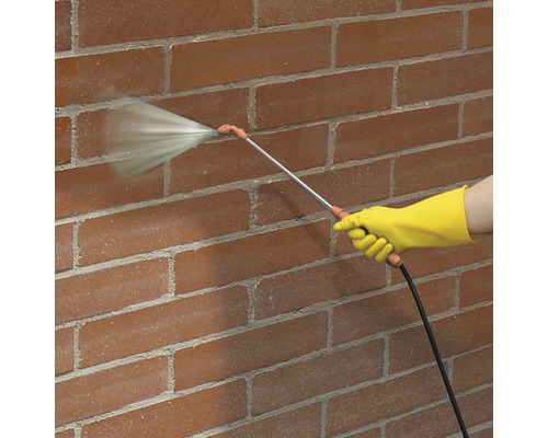 Pulvérisateur en utilisation sur un mur de briques