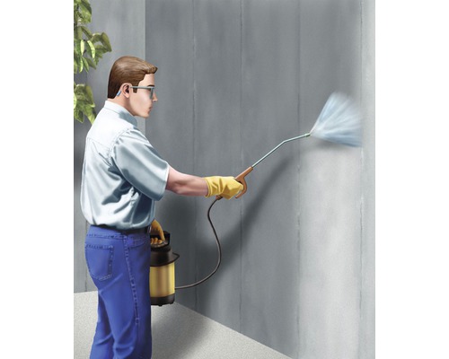 Homme utilisant un pulvérisateur de jardin pour traiter un mur