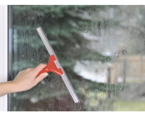 Hand benutzt einen Fensterabzieher an einer Fensterfläche