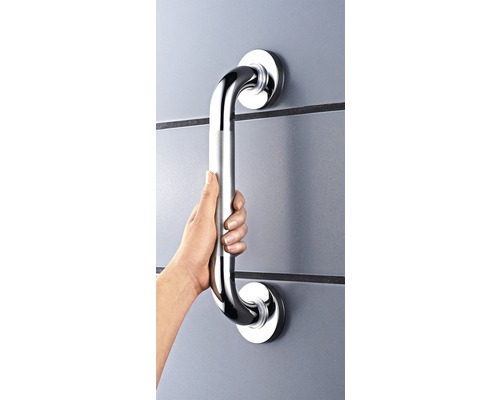 Une main tient une barre d''appui en métal fixée au mur.