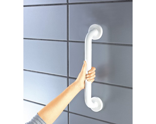 Eine Person hält einen weissen Haltegriff an einer Wand.