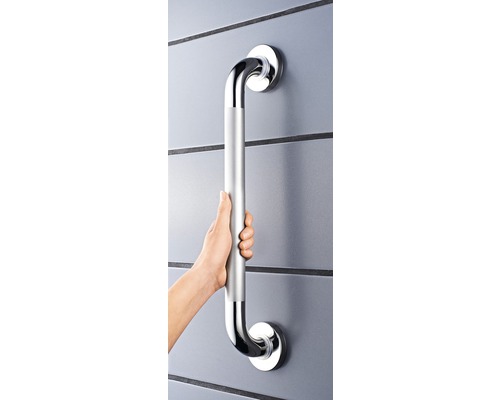 Une personne tient une poignée argentée sur un mur