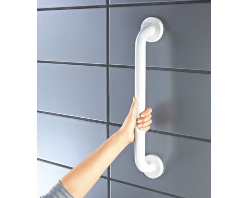 Eine Person hält einen weissen Haltegriff, der an einer gefliesten Wand befestigt ist.