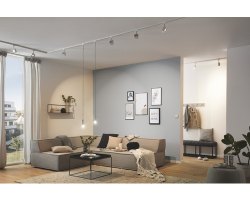 Salon lumineux avec spots de plafond, canapé, décoration murale et parquet