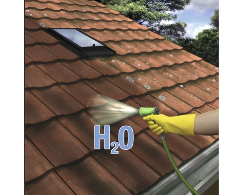 Dachreinigung mit Wasserstrahl und gelben Handschuhen auf einem Ziegeldach mit Dachfenster