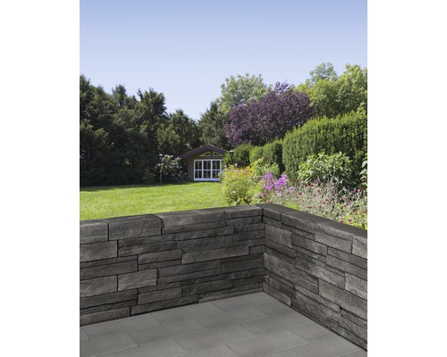 Jardin avec mur en panneaux de pierre et cabanon de jardin