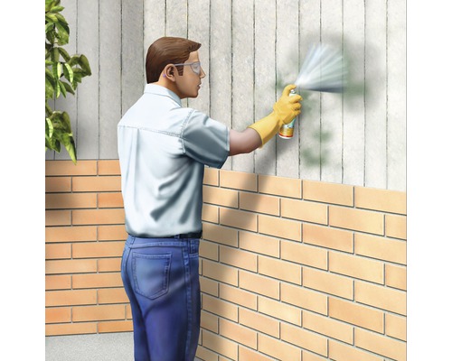Mann mit Schutzbrille und Handschuhen, der eine Wand mit einer Sprühdose behandelt