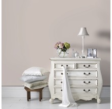 Chambre décorative avec commode, lampe et pile d''oreillers