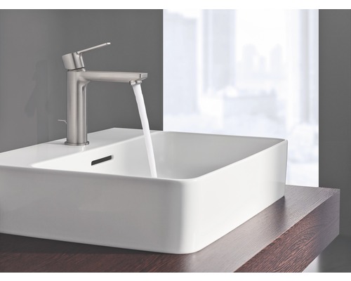 Auf einem Waschtisch ist ein Waschbecken mit Armatur und fließendem Wasser zu sehen.