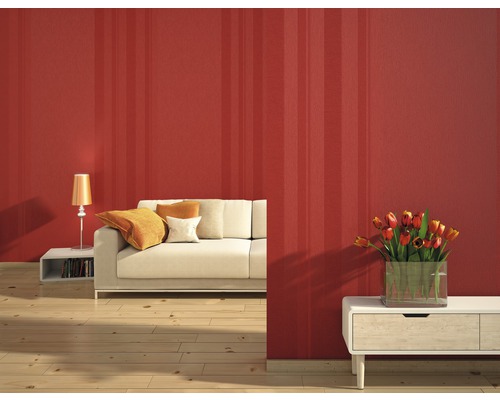 Salon avec papier peint rayé, canapé, lampe de table et vase de fleurs