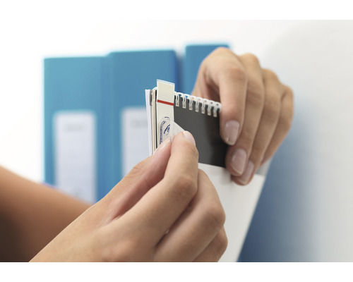 Des mains retirent un autocollant d''un cahier.