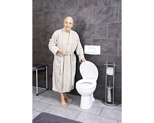 Badezimmer mit Standtoilette und einer Person im Bademantel