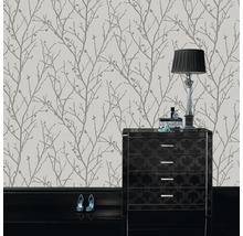 Papier peint à motif de branches d''arbres dans une pièce avec commode et lampe
