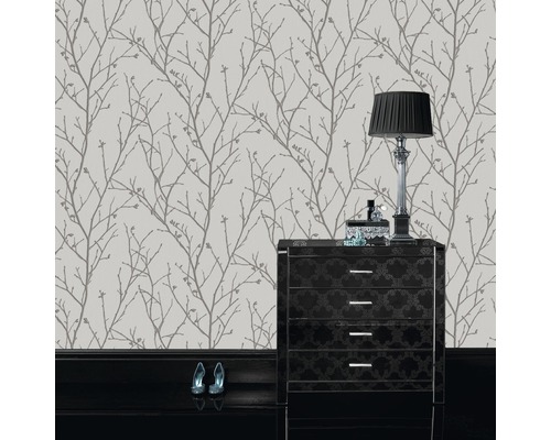 Papier peint à motif de branches d''arbres dans une pièce avec commode et lampe