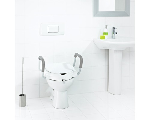 Toilettes avec rehausseur de siège de toilette et barres d''appui dans une salle de bains lumineuse