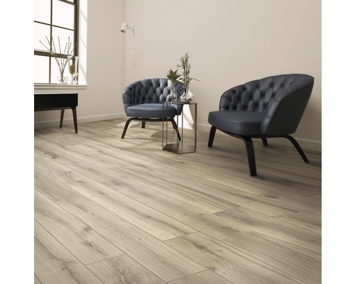 Pièce lumineuse avec plancher en bois, deux fauteuils et table d''appoint