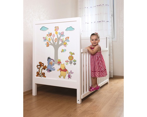 Lit d''enfant blanc avec motifs Winnie l''ourson dans une chambre d''enfant.