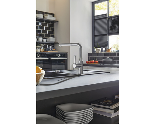 Scène de cuisine avec robinet d''évier, évier et ustensiles de cuisine sur un plan de travail.