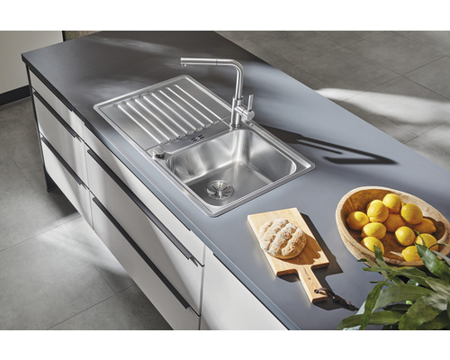 Évier en acier inoxydable avec égouttoir et robinet sur un comptoir de cuisine