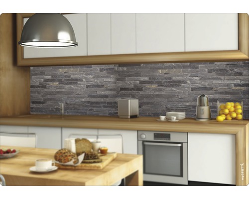 Scène de cuisine avec une crédence aspect pierre derrière le plan de travail