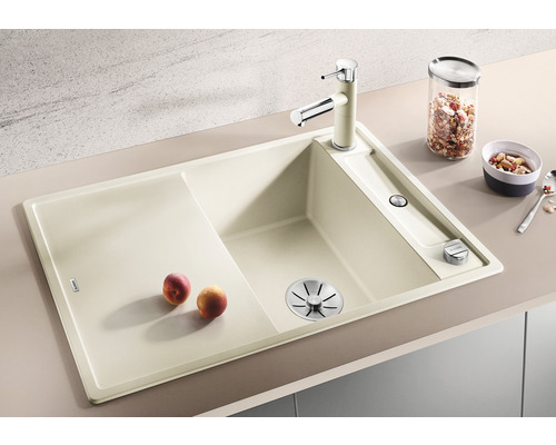 Évier de cuisine beige avec égouttoir, robinet et distributeur de savon.