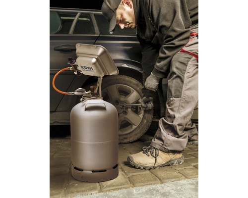 Radiateur radiant ROWI avec bouteille de gaz et personne changeant les pneus