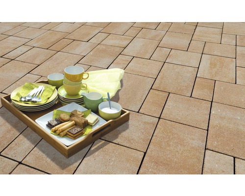 Terrasse avec pavés en béton et plateau avec vaisselle et pâtisseries