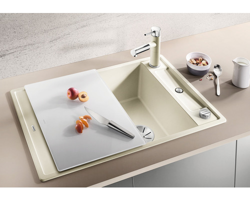 Évier de cuisine avec planche à découper, robinetterie et fruits