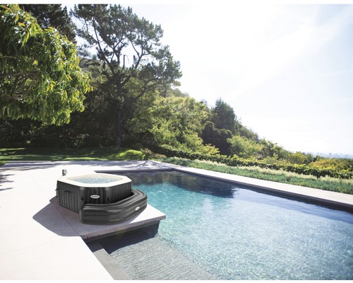 Aufblasbarer Whirlpool der Marke Intex neben einem Pool im Garten.