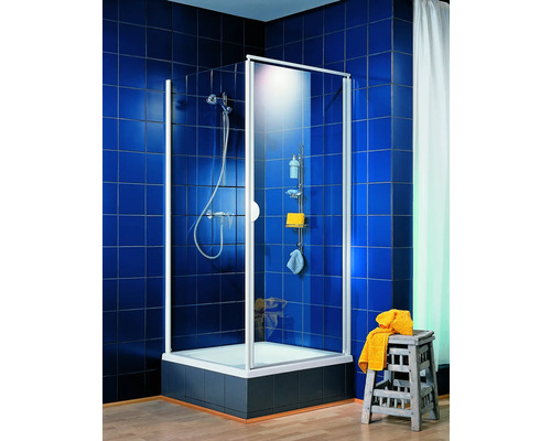 Cabine de douche avec robinetterie de douche et étagère dans une salle de bains carrelée en bleu