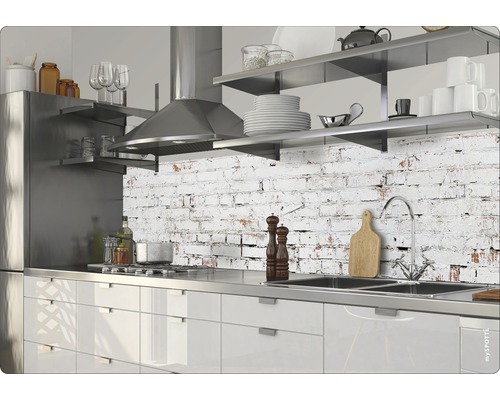 Cuisine moderne avec appareils en acier inoxydable et plan de travail devant un mur à motifs de briques