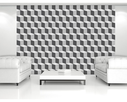 Salon avec papier peint géométrique à cubes en gris et blanc, deux fauteuils et une table