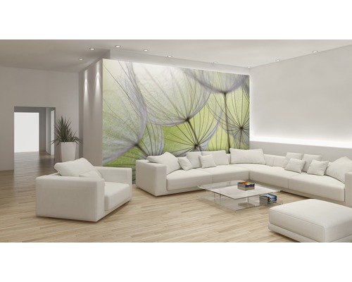 Heller Wohnraum mit weißer Eckcouch, Sessel, Glastisch und Fototapete mit Pusteblumen-Motiv