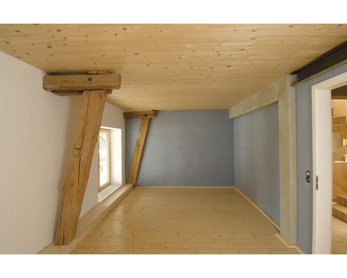 Pièce lumineuse avec poutres en bois, plafond en bois et plancher en bois.