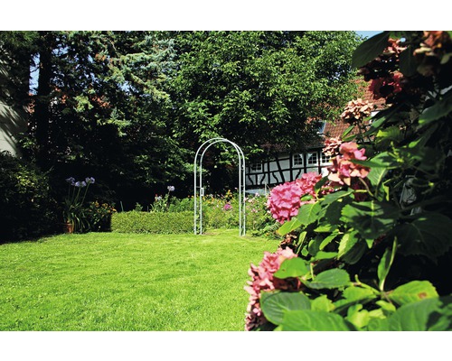 Garten mit Rasenfläche und Rosenbogen