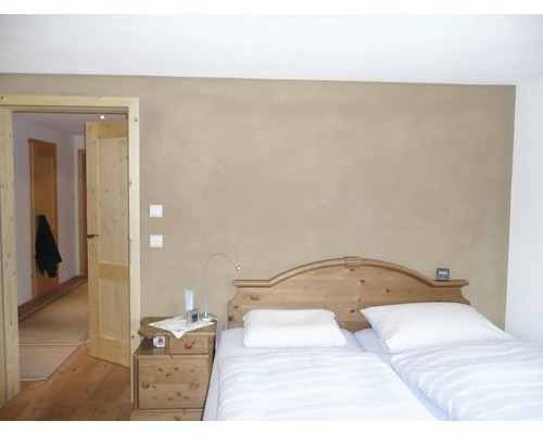 Chambre avec lit en bois, table de chevet et porte ouverte