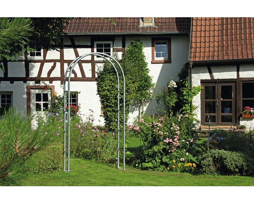 Metall-Rosenbogen im Garten vor einem Haus
