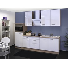Moderne Küche mit weißen Schränken, Spüle und Kochfeld vor einer blauen Wand.
