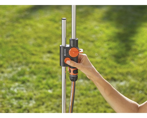 Distributeur d''eau Gardena avec main sur le régulateur pour l''arrosage du jardin