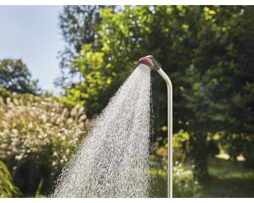 Douche de jardin avec eau courante devant une végétation verdoyante
