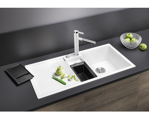 Spüle mit Abtropffläche, Wasserhahn und Zubehör auf einer Küchentheke.