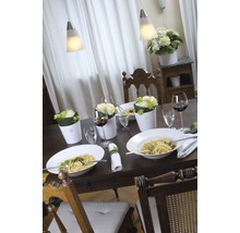 Table à manger dressée avec des pâtes, des fleurs et du vin sous des suspensions