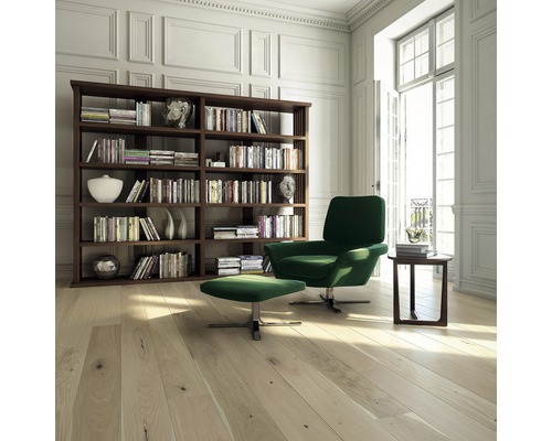 Helles Wohnzimmer mit Bücherregal, Sessel, Hocker und Holzboden