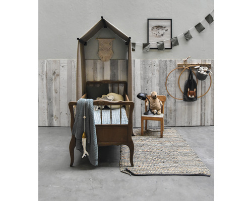 Kinderzimmer mit Kinderbett mit Betthimmel, Teddybär auf Stuhl und Teppich