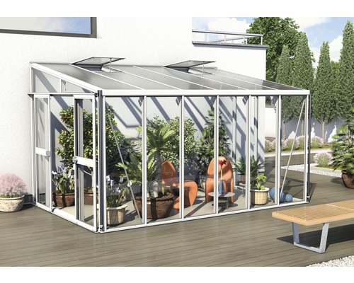 Gewächshaus mit Pflanzen und Gartenmöbeln auf einer Terrasse