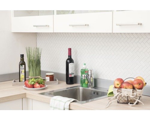 Scène de cuisine avec évier, robinet et divers ustensiles de cuisine sur le plan de travail.