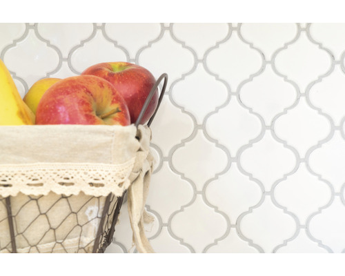 Dekorative Fliesenwand mit Obstkorb im Vordergrund.